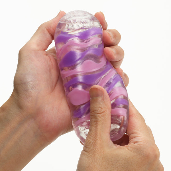 TENGA ARTE DRAPE 於手中擠壓展示,柔軟材質提供彈性與貼合度。