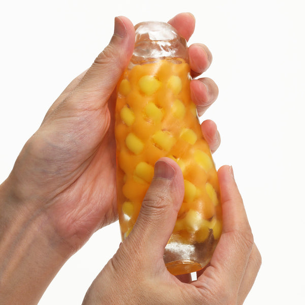 手持 TENGA ARTE TWEED 織紋杯,擠壓展示柔軟回彈材質,提供舒適緊密包覆感。